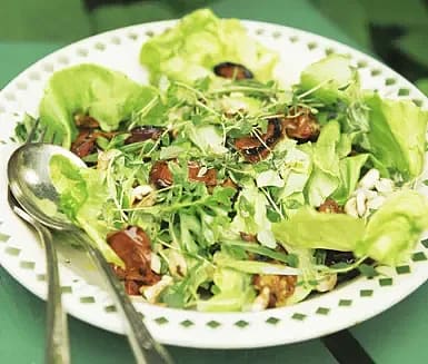 Gröna blandade blad med rostade tomater och örter